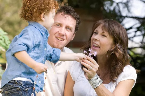 child boy is giving flower to mother