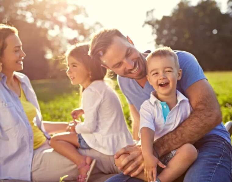 Foster parents and children laughing with family