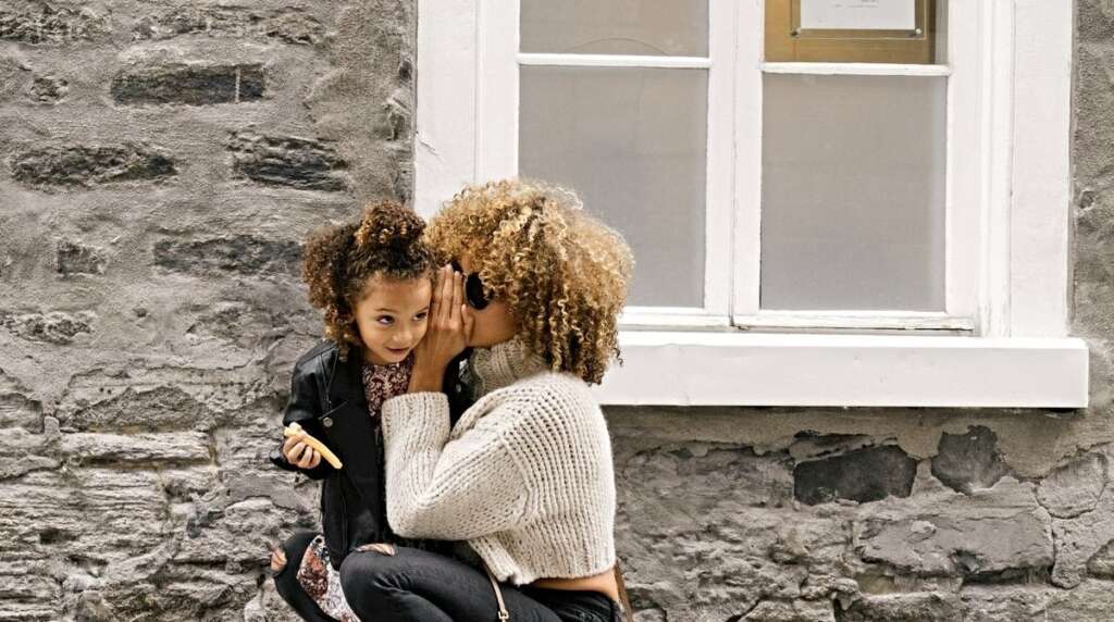 mother is saying something to her daughter