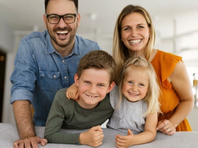 Mother, father, and children are smiling together as a happy family