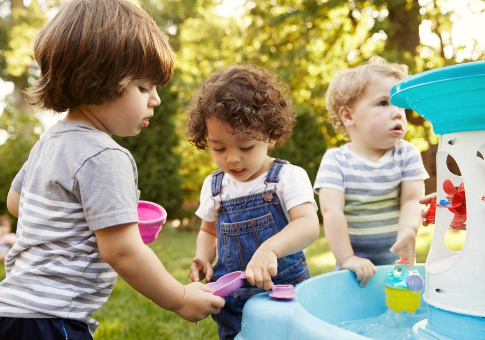 toddlers are playing with water outside of home