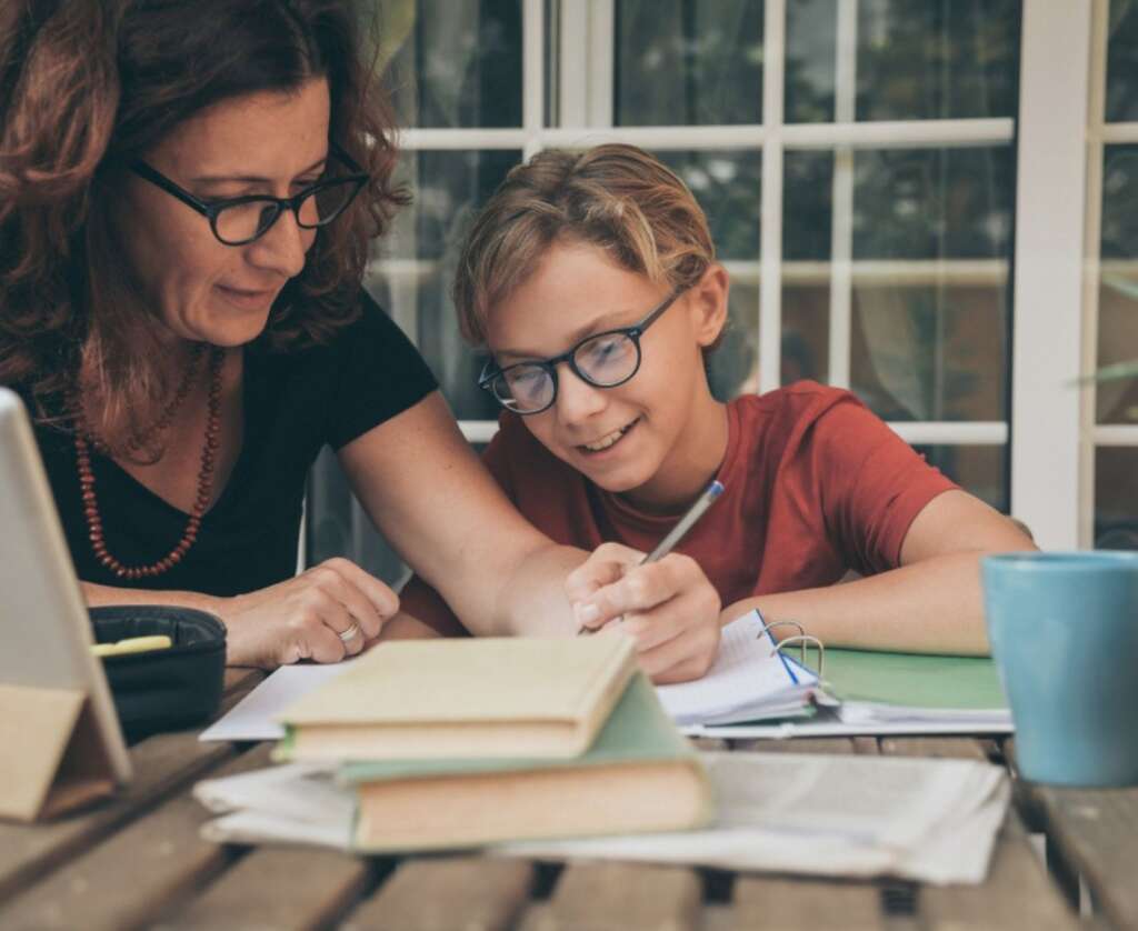 mother is teaching and helping her son in academics.
