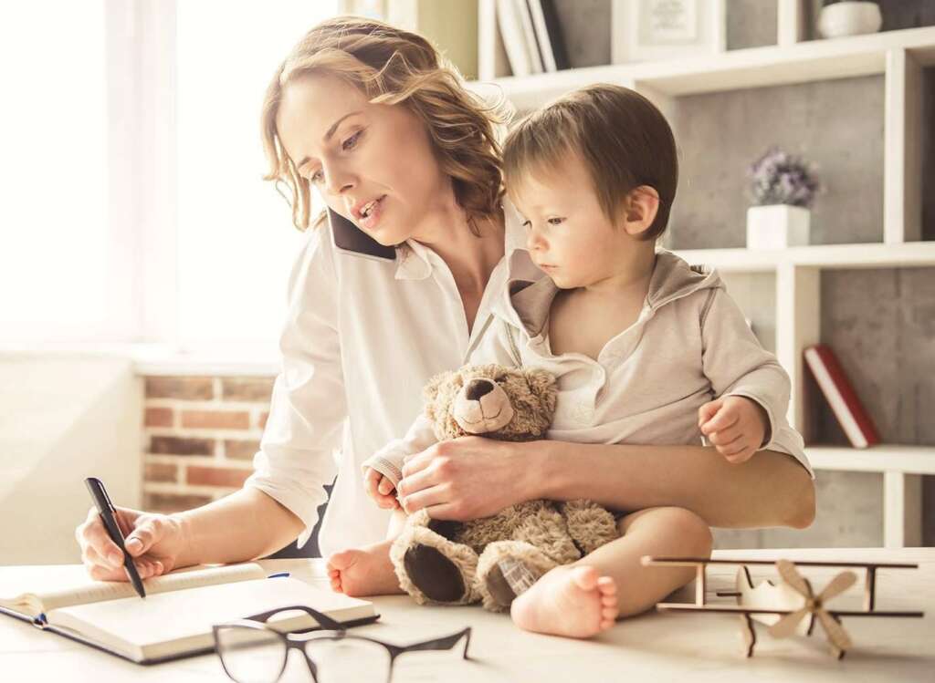 mother is bust at home work but teaching her child. stay at home mom